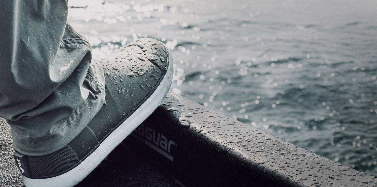 Water-beaded gray boat shoe resting on a wet boat deck